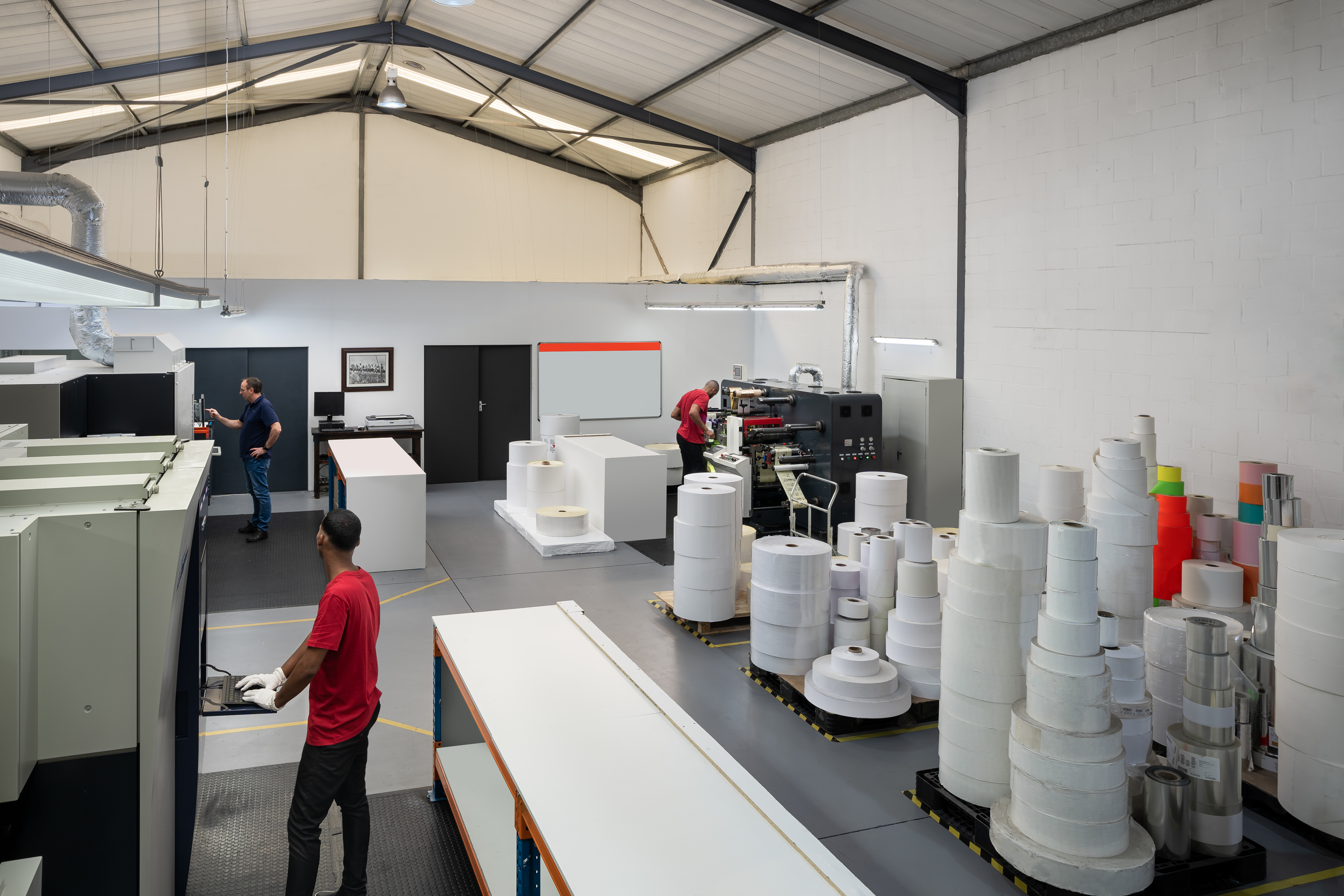 Wide view of Sign & Seal Labels production floor with multiple presses and workers