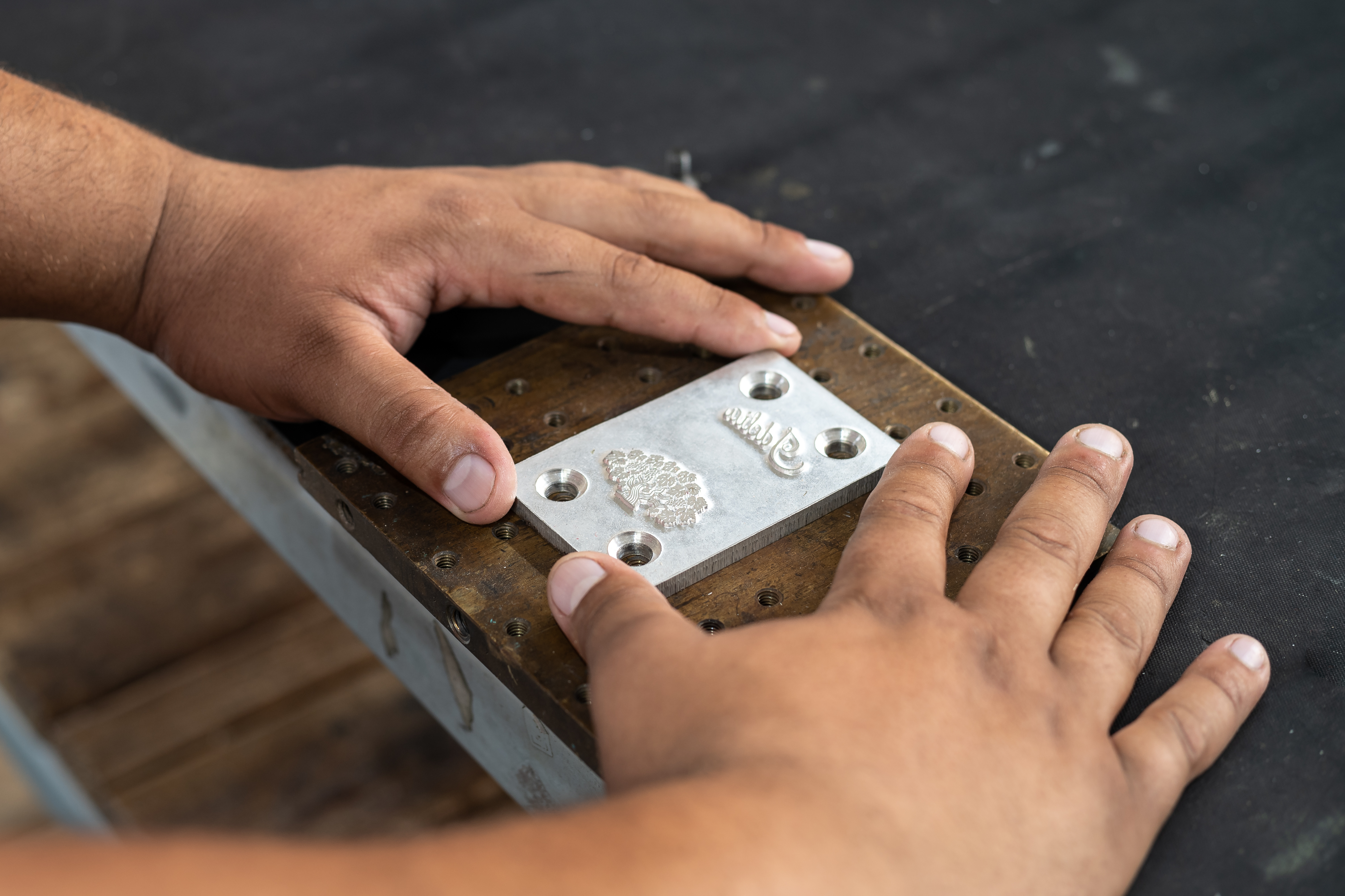 Hands placing embossing die block for label production